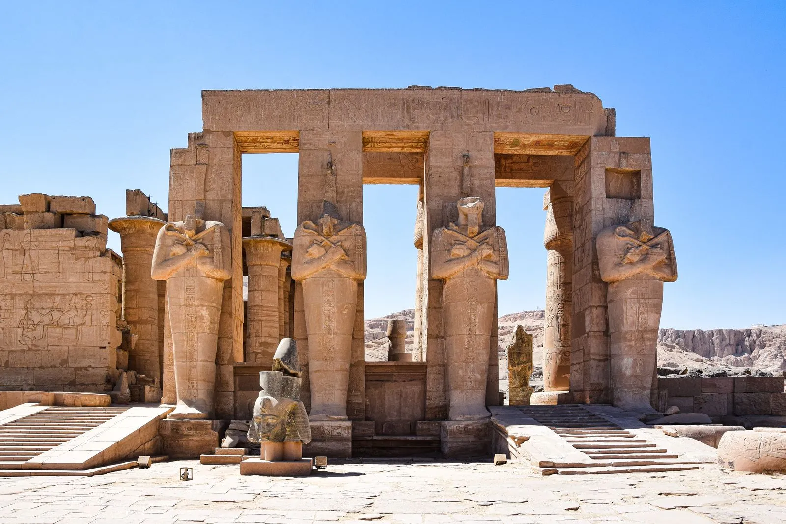 Osiride pillar statues in front of a stone portico at the Ramesseum