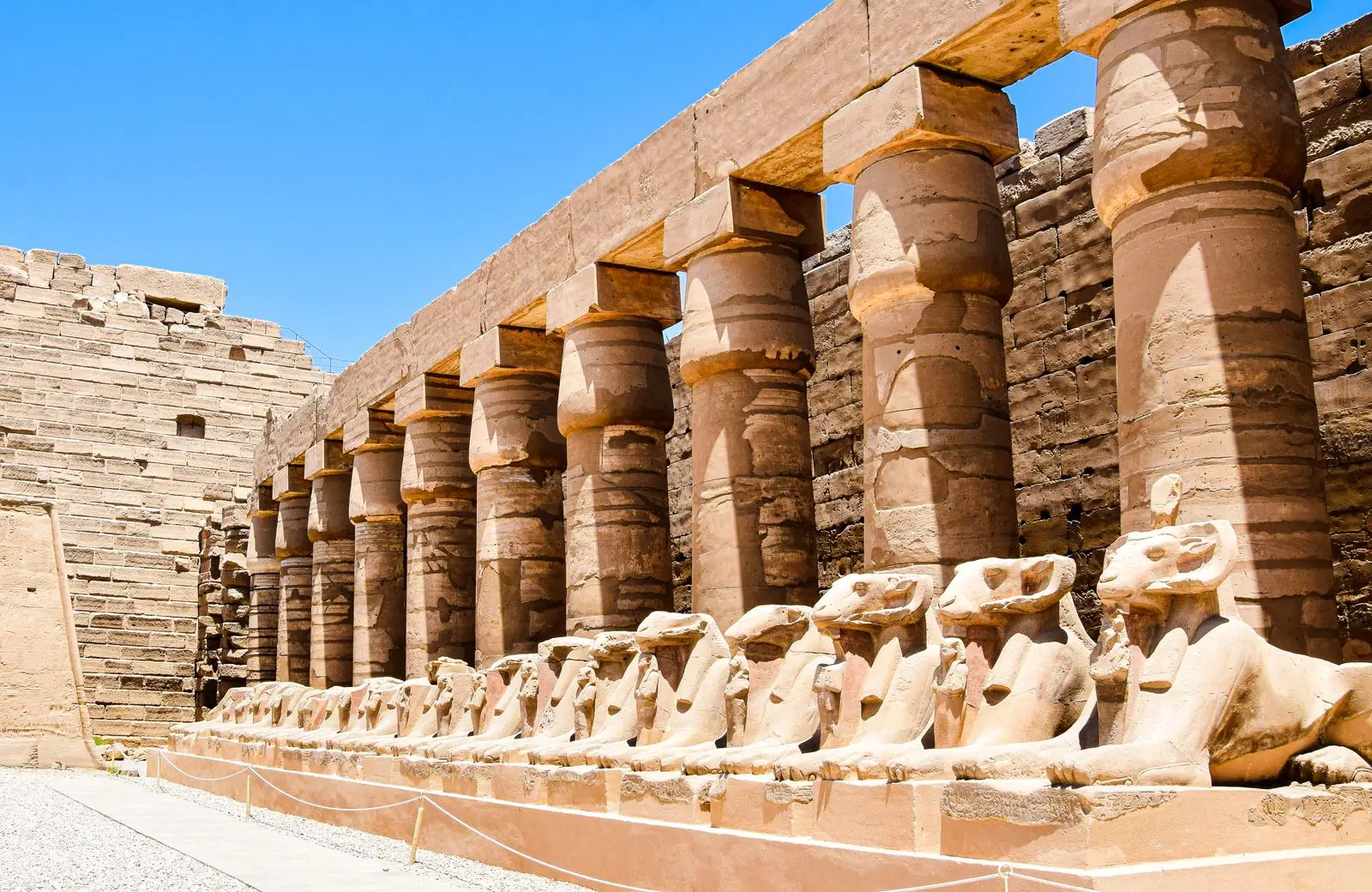 Ram-headed sphinxes beneath a colonnade in Karnak's first court