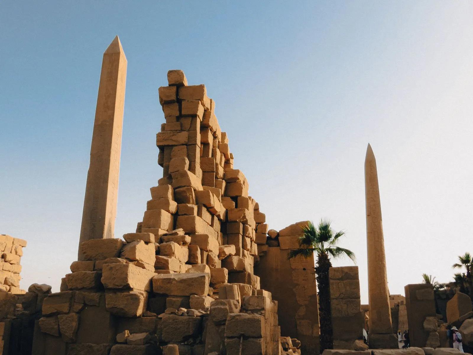 Two obelisks rising above tumbled stone ruins at Karnak
