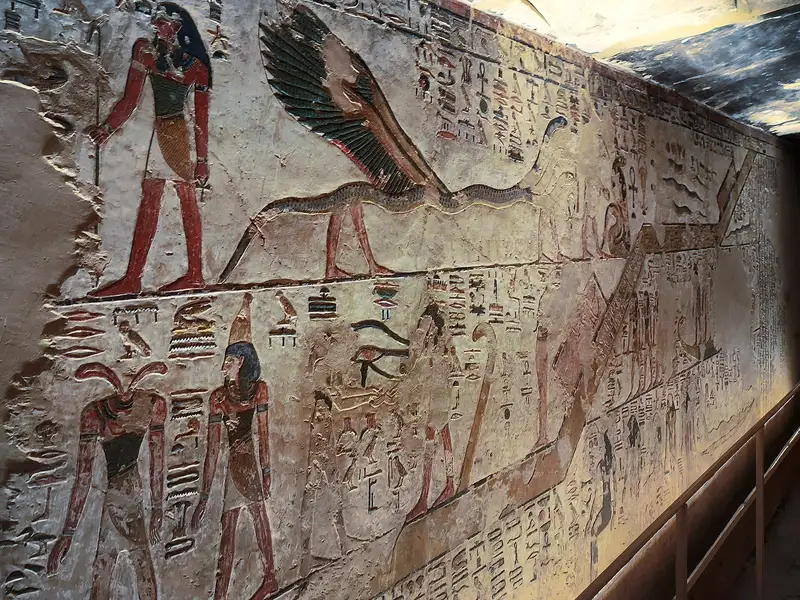 Long painted corridor wall in Seti I's tomb with gods, serpents and a wooden handrail