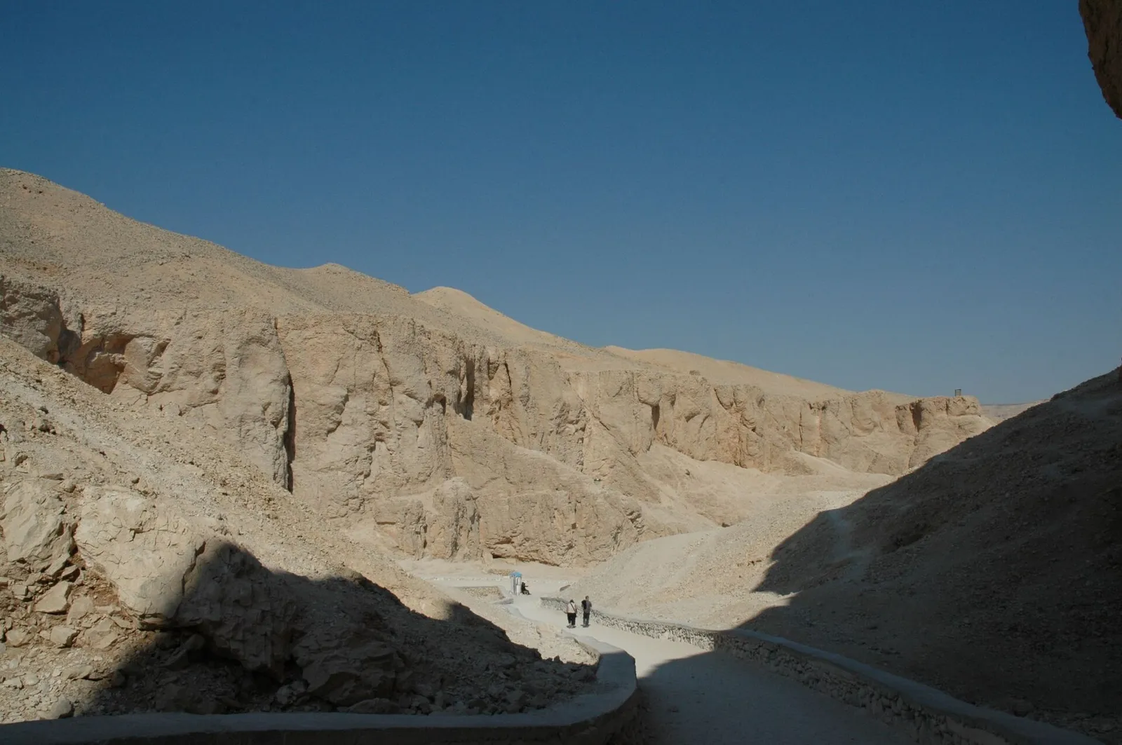 Path into the Valley of the Kings between pale limestone cliffs, half in shade