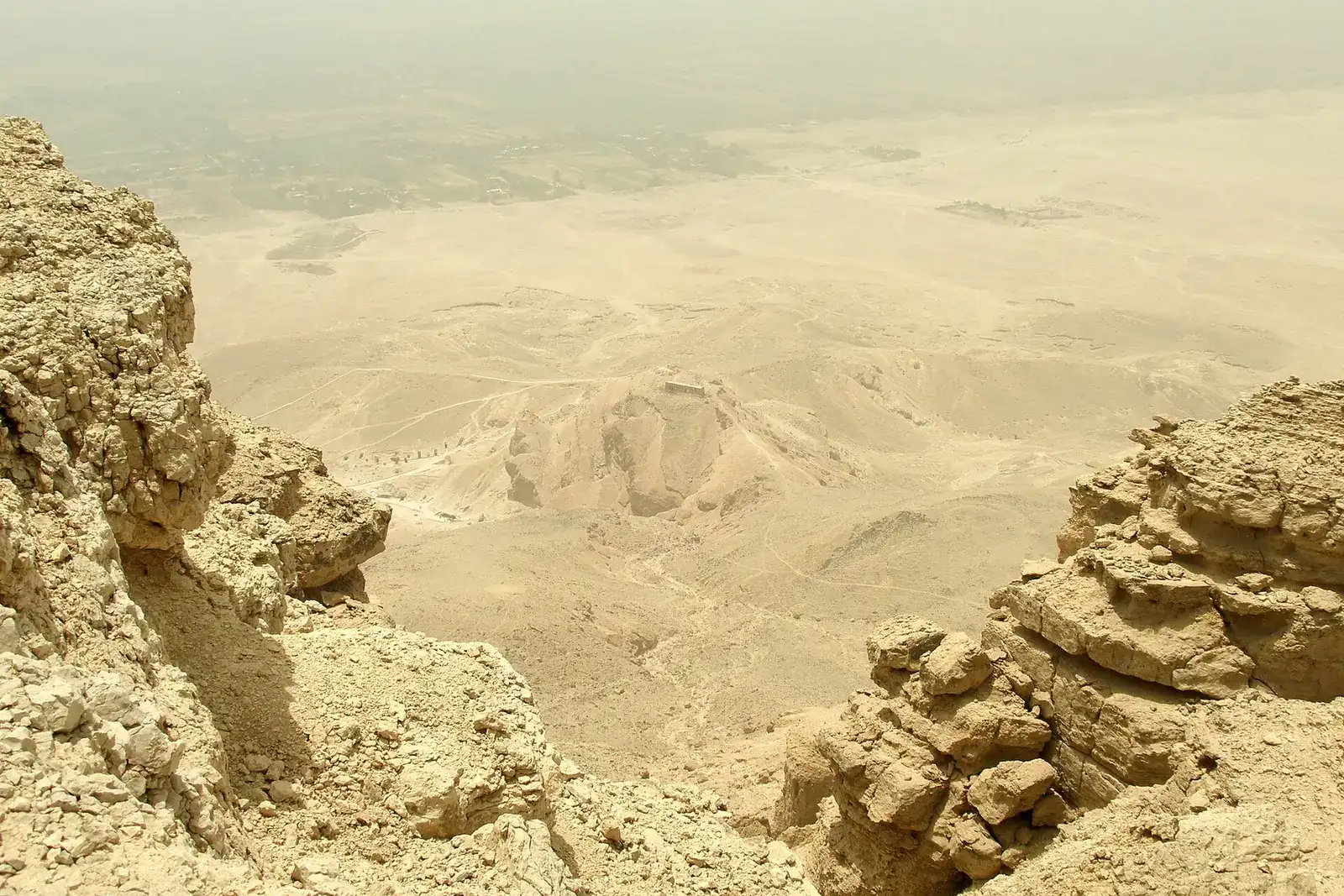 Hazy view from the Theban cliffs down over the desert and the green Nile valley