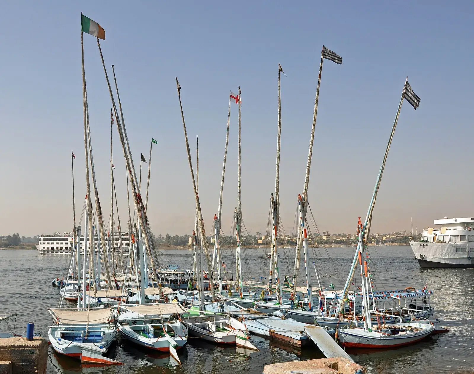 Feluccas moored on the Nile at Luxor with cruise boats behind