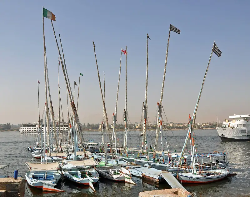 Feluccas moored on the Nile at Luxor with cruise boats behind