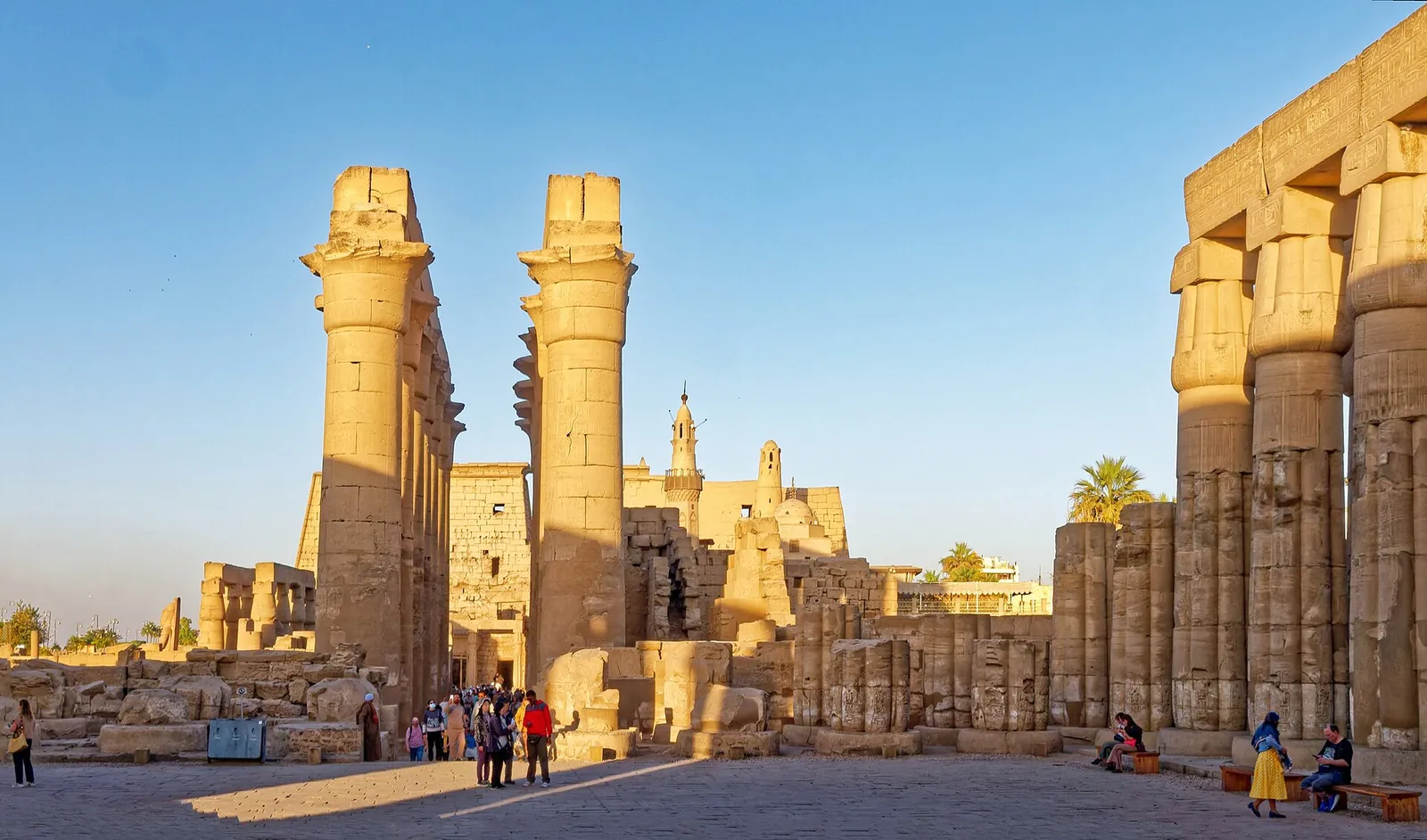 Columns of Luxor Temple in late-afternoon light, the Abu Haggag minaret behind