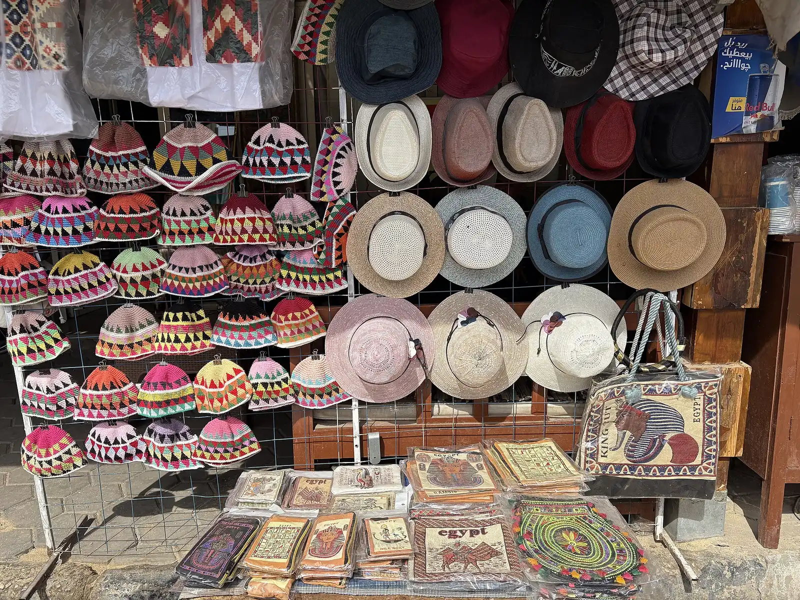 Souvenir stall with embroidered caps, sun hats and papyrus prints