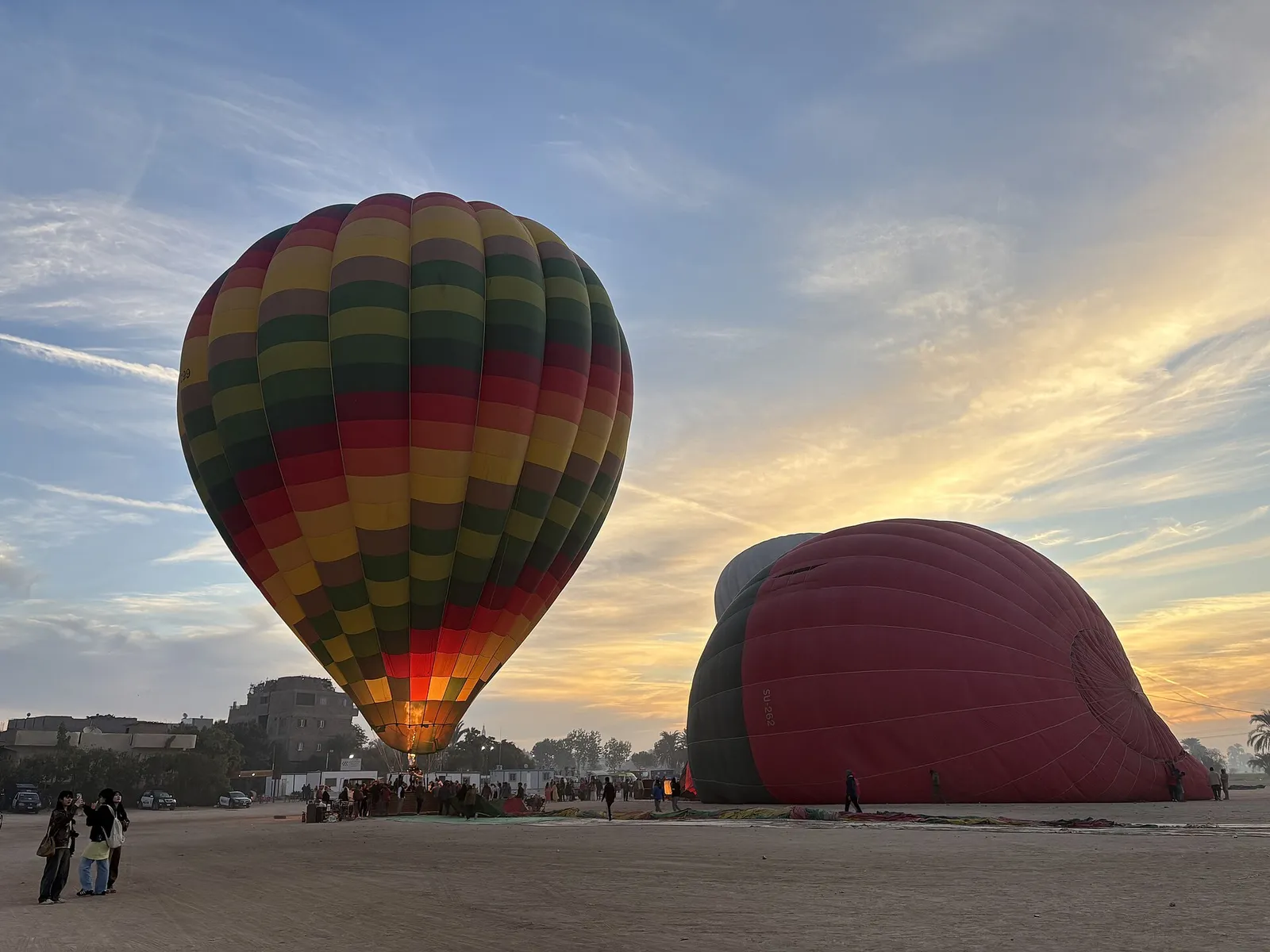 Striped balloon glowing as it inflates at sunrise