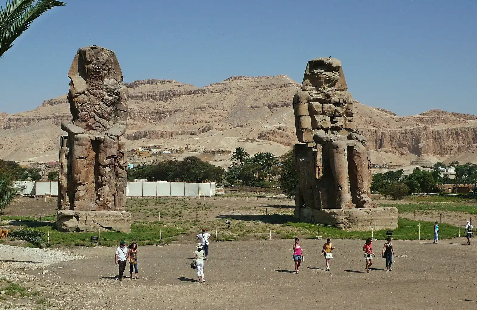 Both Colossi of Memnon with the Theban hills behind