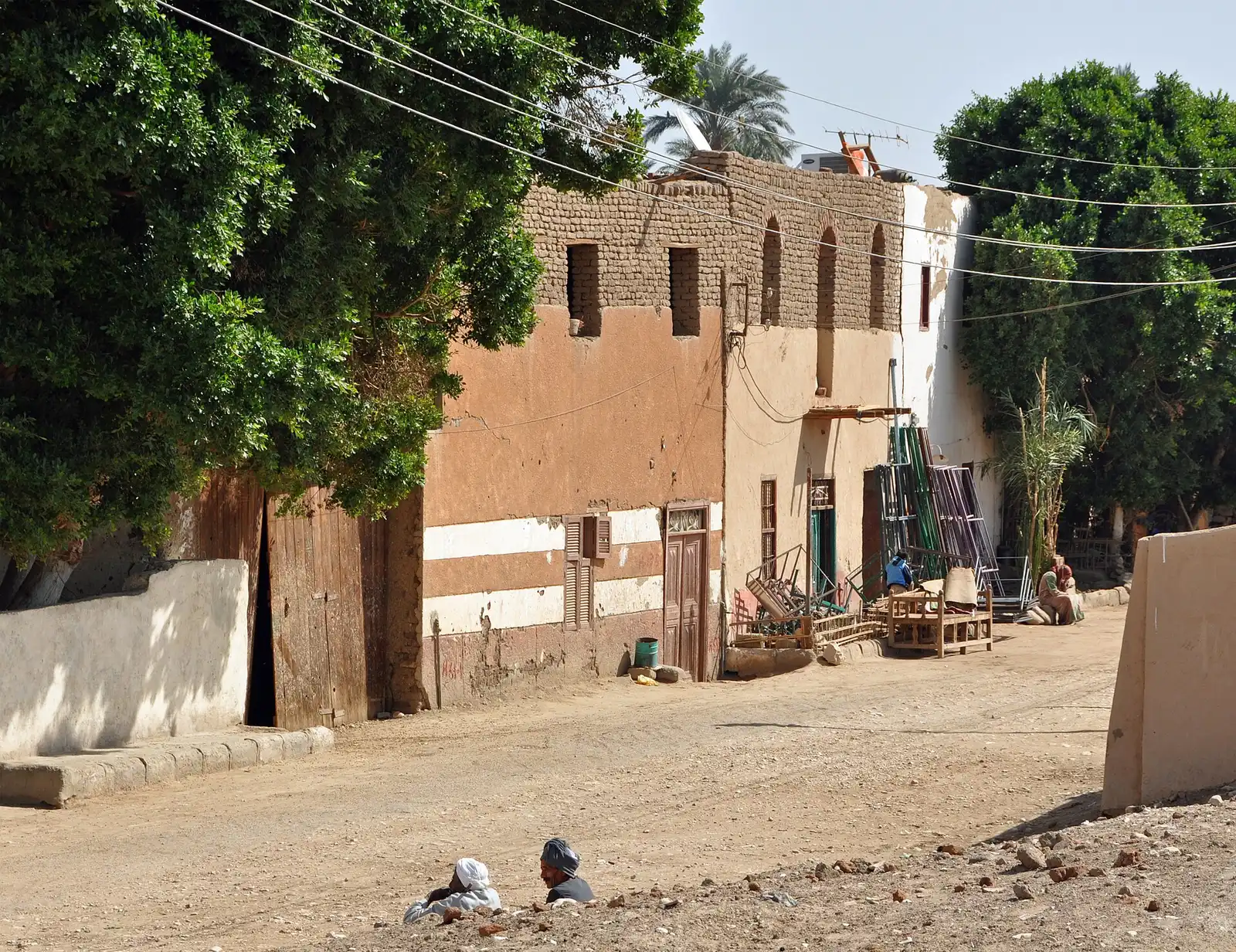 Village street of mud-brick houses under trees