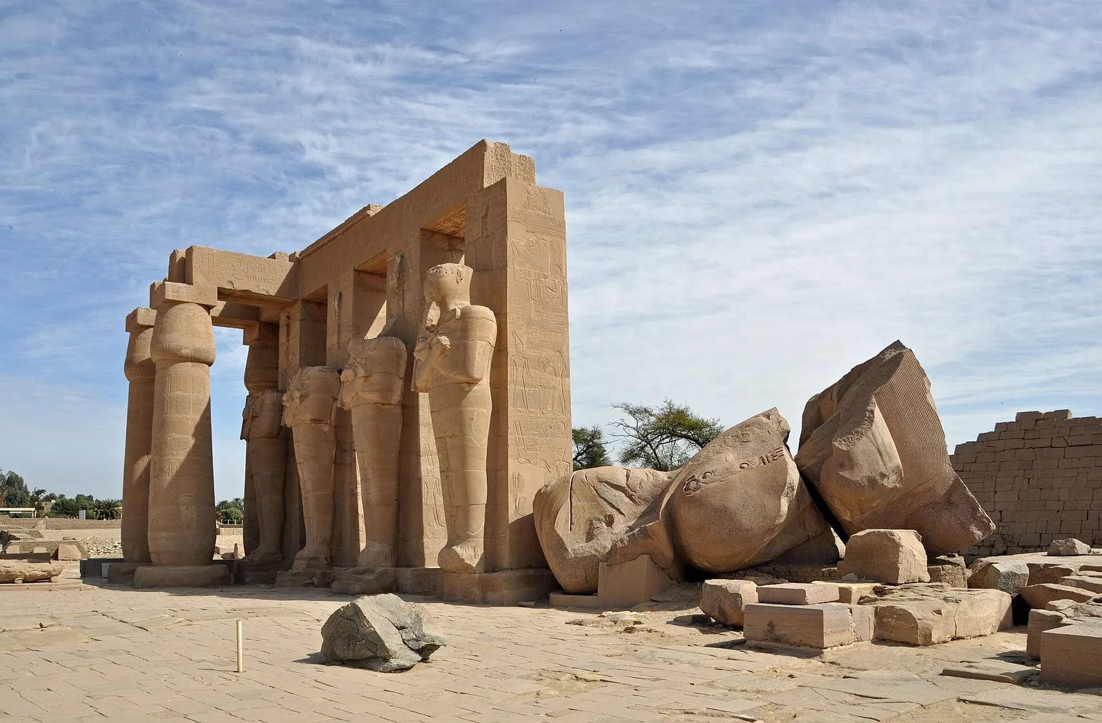 Osiride pillars of Ramesses II beside the toppled granite colossus at the Ramesseum