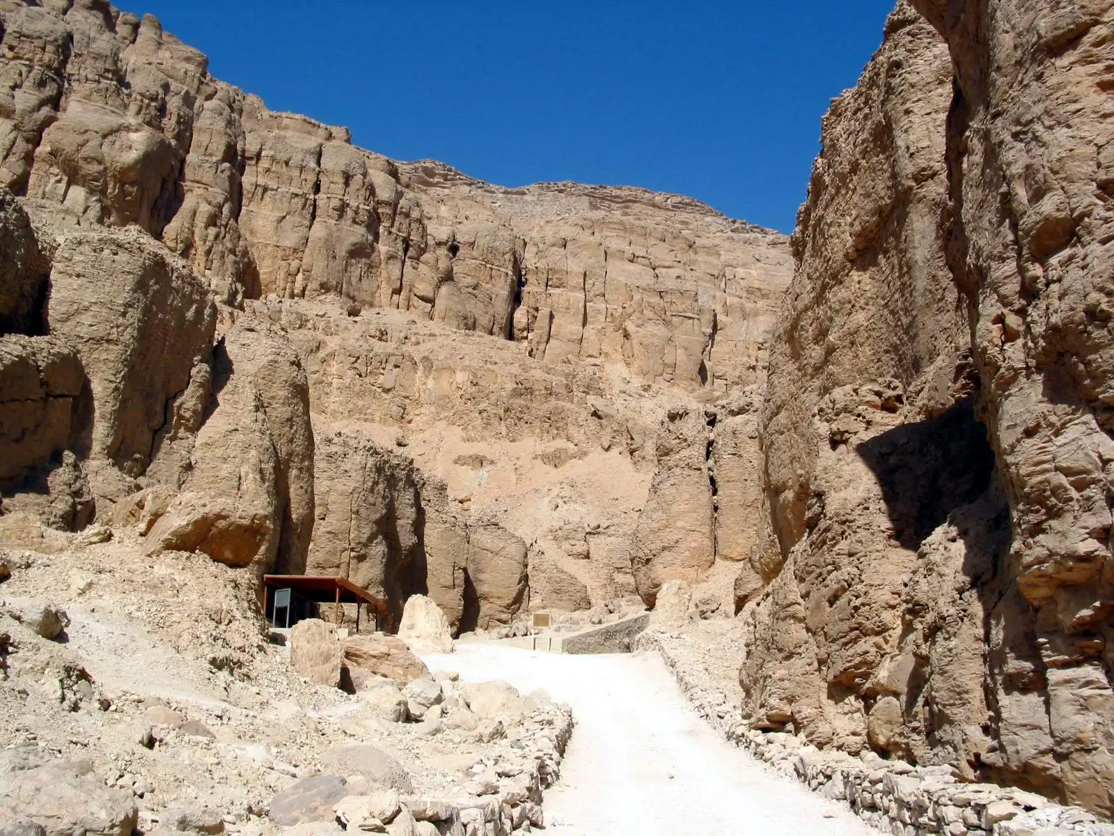 Paved path between steep limestone cliffs to a tomb entrance in the Valley of the Kings