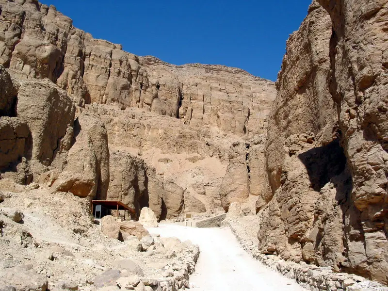 Paved path between steep limestone cliffs to a tomb entrance in the Valley of the Kings