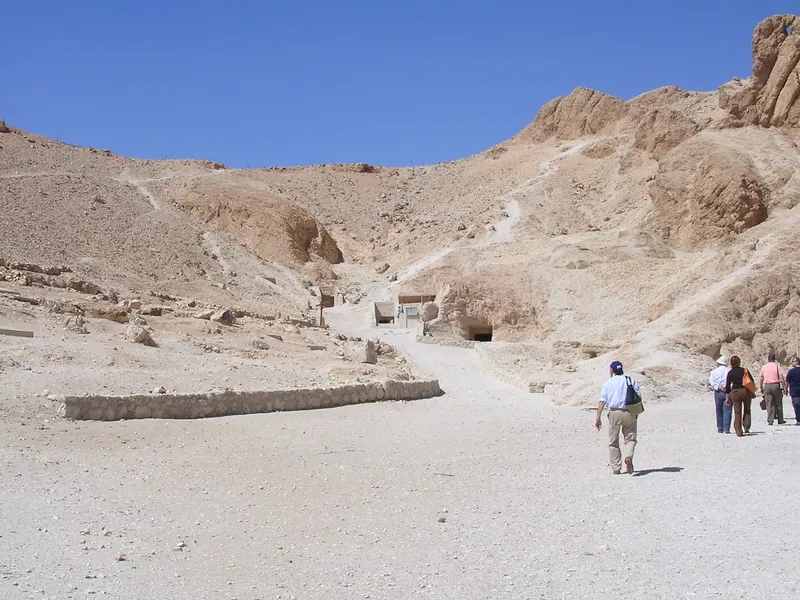 Visitors walking up the main path toward tomb entrances in the Valley of the Queens