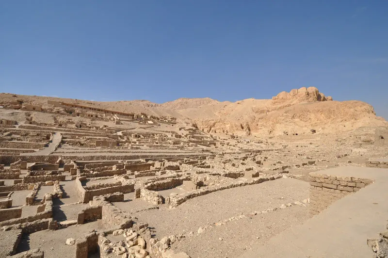 The excavated village of Deir el-Medina below the Theban hills under a clear sky