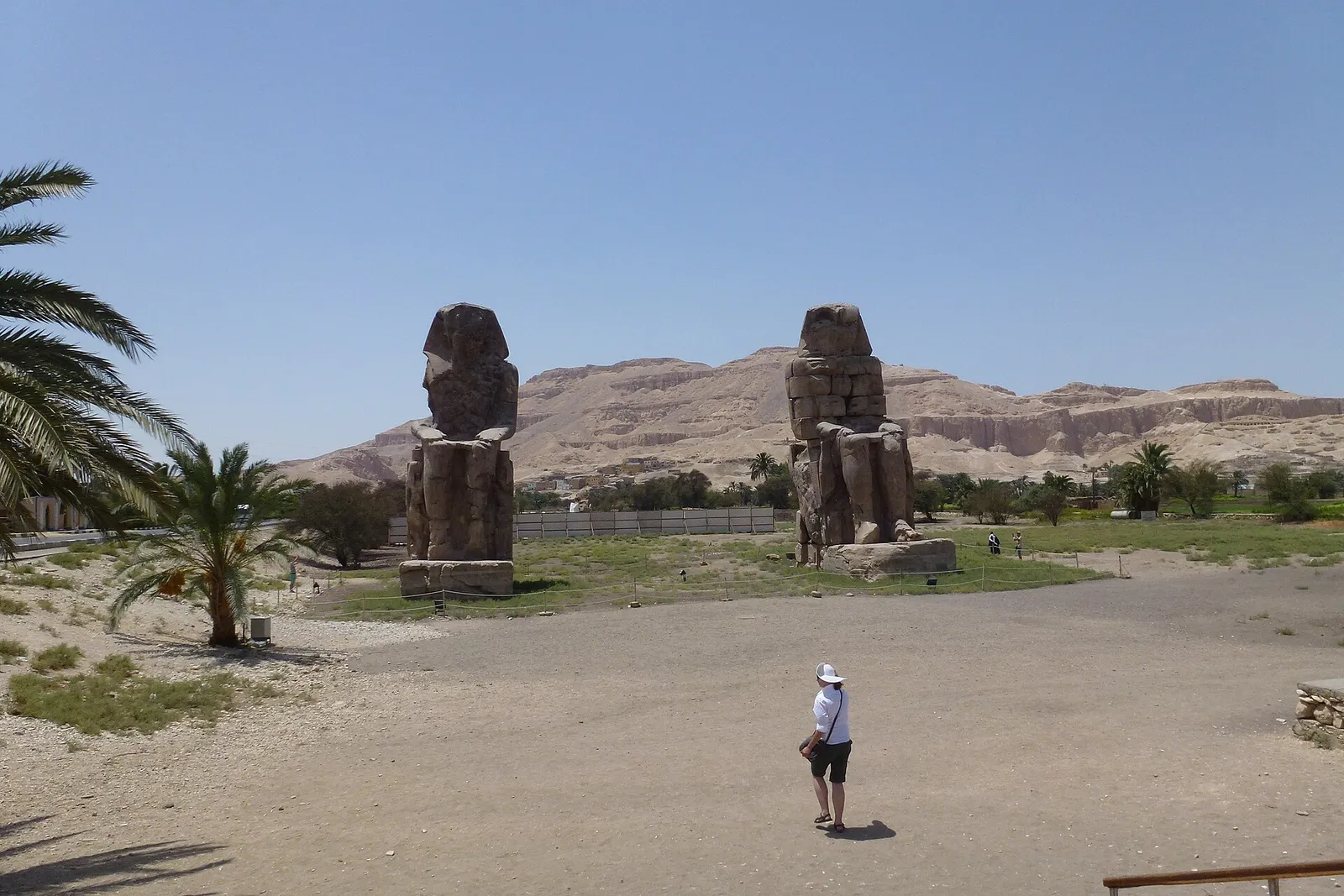 The two Colossi of Memnon on the West Bank plain, with a lone visitor in front