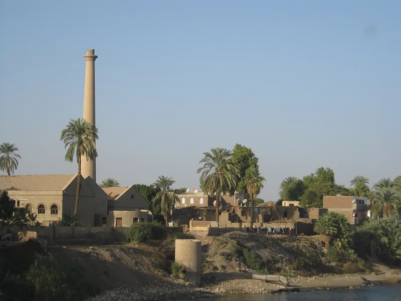 Old brickworks chimney and houses on the Nile bank