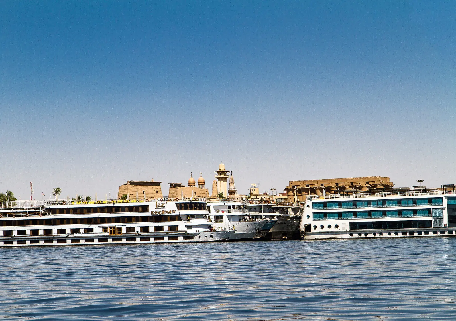 Nile cruise boats moored below Luxor Temple