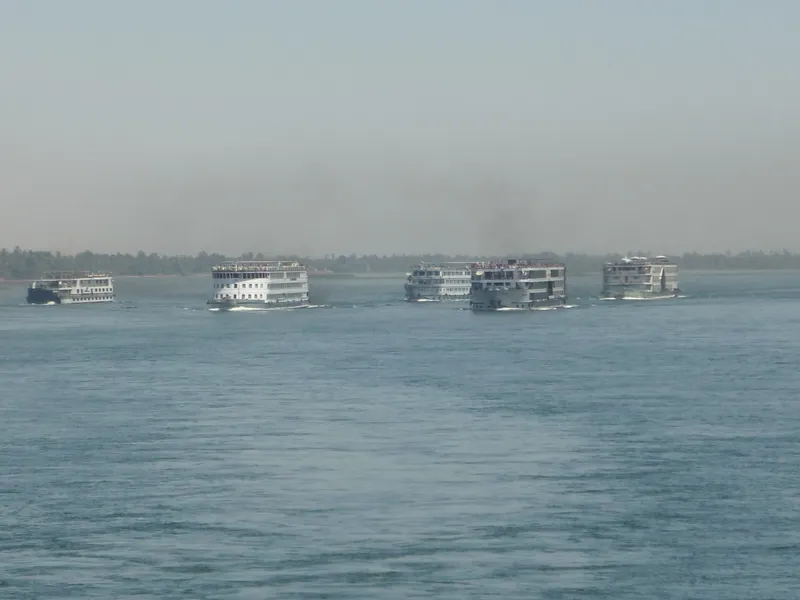 Five Nile cruise ships sailing in a line on a hazy day
